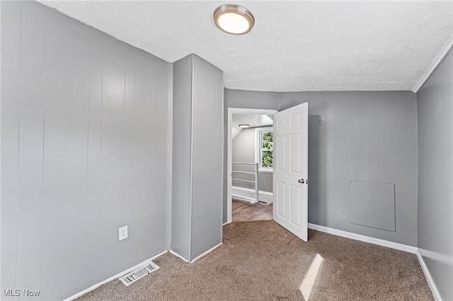 carpeted spare room featuring a textured ceiling