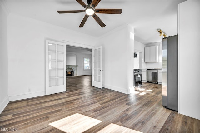 interior space featuring ceiling fan, french doors, crown molding, and dark wood-type flooring