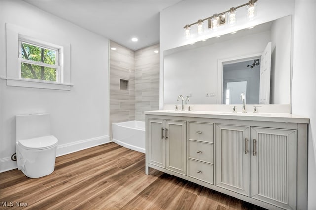 full bathroom with toilet, hardwood / wood-style flooring, vanity, and separate shower and tub