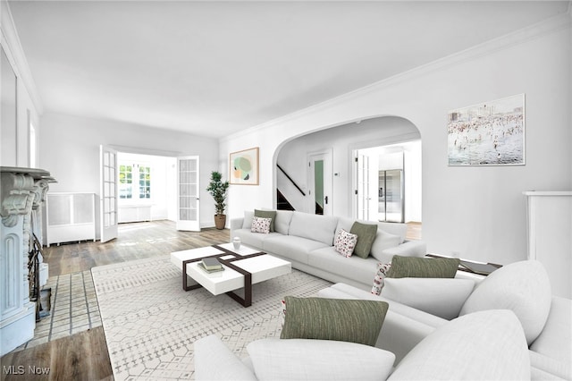 living room with wood-type flooring and ornamental molding