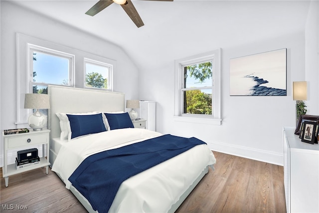 bedroom featuring multiple windows, wood-type flooring, vaulted ceiling, and ceiling fan