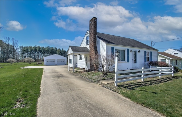 view of front facade with a garage, an outbuilding, and a front lawn