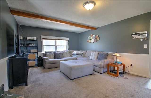 living room with a textured ceiling, carpet flooring, and beam ceiling