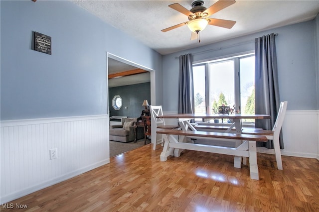 dining room with a textured ceiling, ceiling fan, and hardwood / wood-style flooring