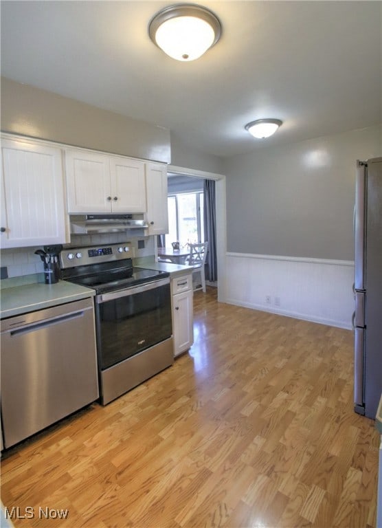 kitchen featuring appliances with stainless steel finishes, light hardwood / wood-style floors, decorative backsplash, and white cabinetry