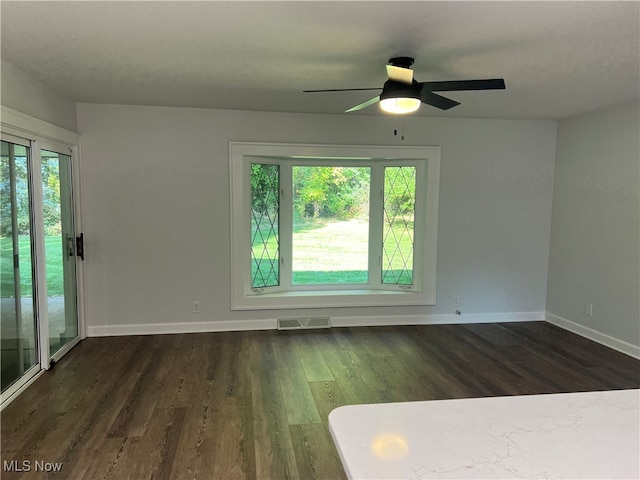 unfurnished room with dark hardwood / wood-style flooring, ceiling fan, and plenty of natural light