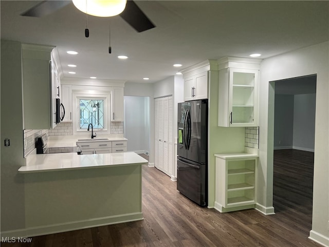 kitchen featuring sink, white cabinetry, stove, dark wood-type flooring, and black fridge with ice dispenser