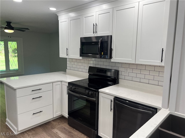 kitchen with kitchen peninsula, tasteful backsplash, white cabinetry, wood-type flooring, and black appliances