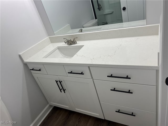 bathroom with vanity, hardwood / wood-style floors, and toilet