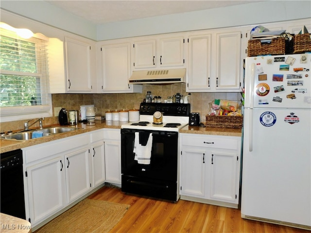 kitchen featuring range hood, white cabinets, sink, and black appliances