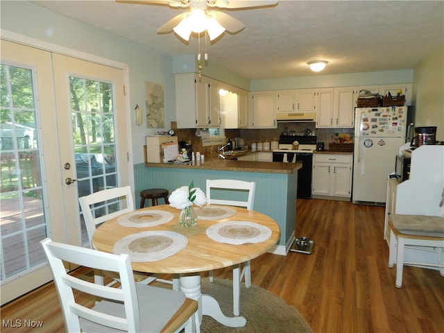 kitchen featuring white cabinets, white appliances, kitchen peninsula, and dark wood-type flooring