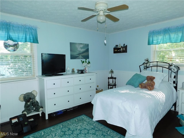 bedroom featuring a textured ceiling, ornamental molding, dark hardwood / wood-style floors, and ceiling fan