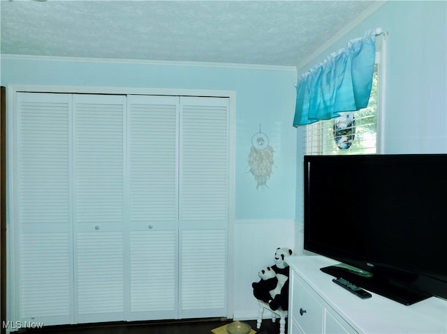 bedroom with a textured ceiling, a closet, and crown molding