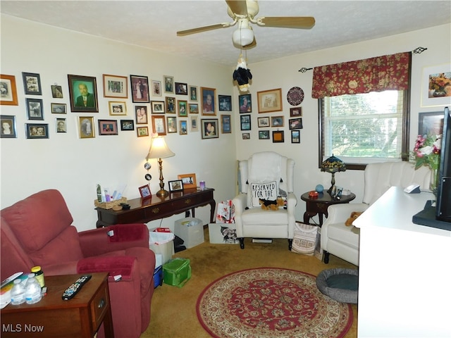 living area featuring a textured ceiling, carpet, and ceiling fan