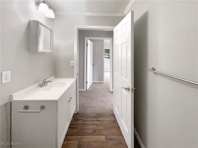 bathroom with wood-type flooring, vanity, and crown molding