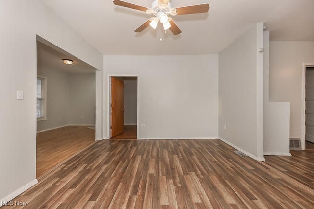 empty room with ceiling fan and dark wood-type flooring