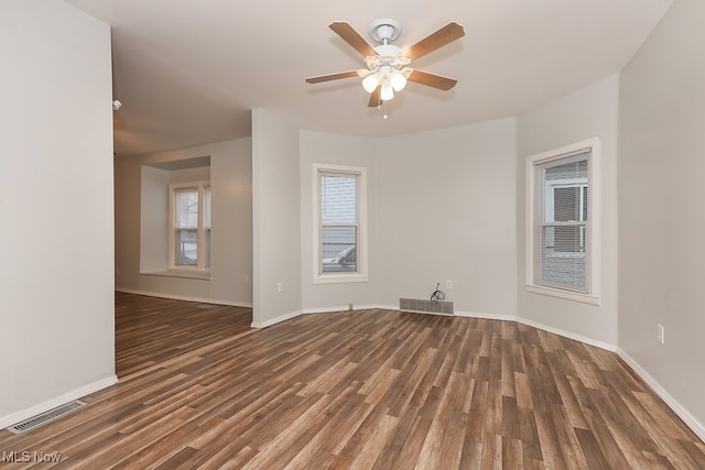 empty room featuring ceiling fan and dark wood-type flooring