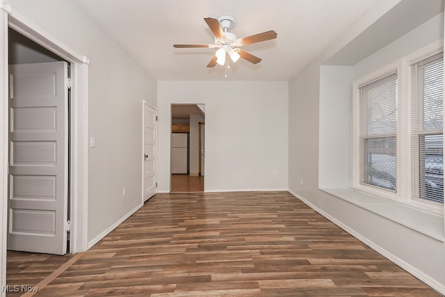 spare room featuring ceiling fan and dark hardwood / wood-style flooring