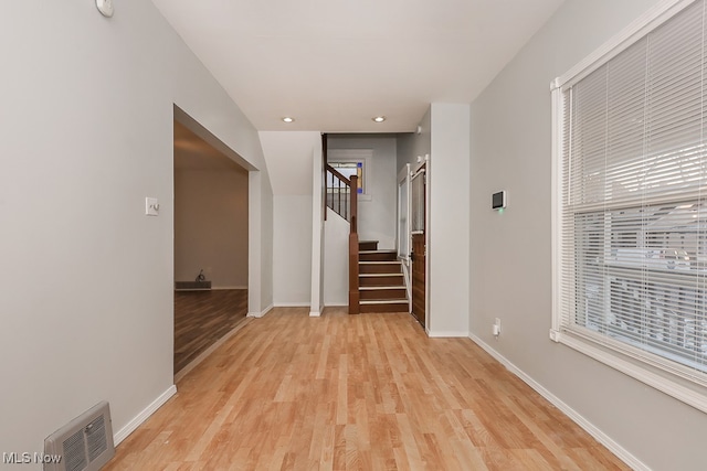 hallway with light hardwood / wood-style floors