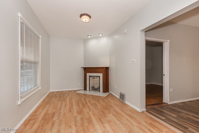 unfurnished living room featuring light hardwood / wood-style floors and a fireplace