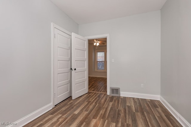 empty room featuring ceiling fan and dark hardwood / wood-style flooring