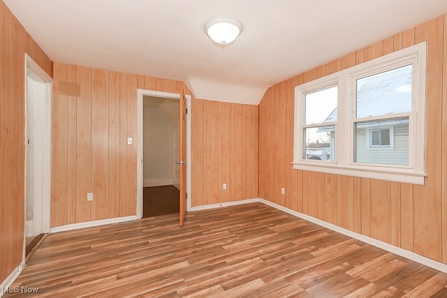 unfurnished room with wood walls and hardwood / wood-style floors