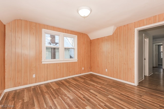 bonus room with wood walls and dark hardwood / wood-style flooring