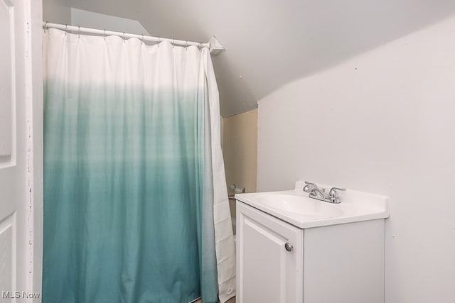 bathroom with vanity and lofted ceiling