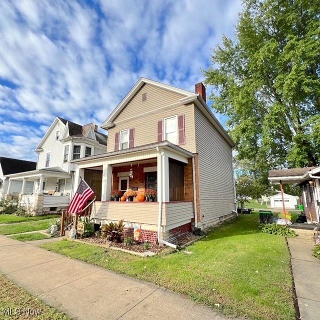 view of front of property with a porch and a front lawn