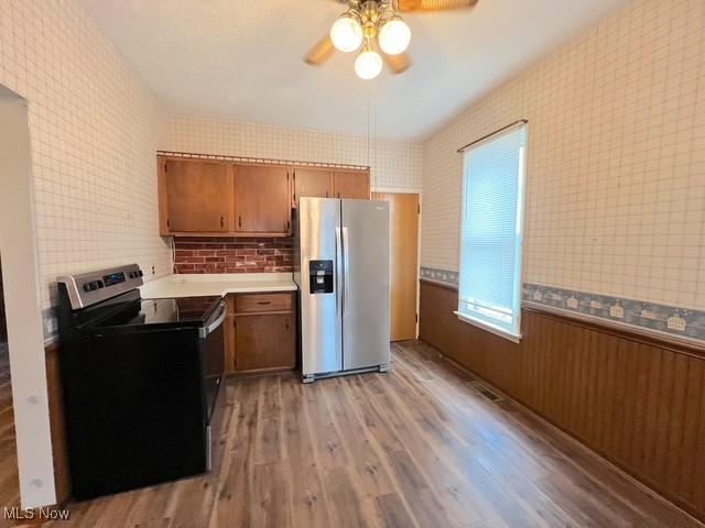 kitchen with appliances with stainless steel finishes, light wood-type flooring, and ceiling fan