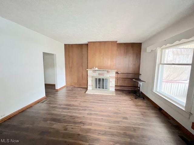 unfurnished living room featuring dark hardwood / wood-style floors and a fireplace