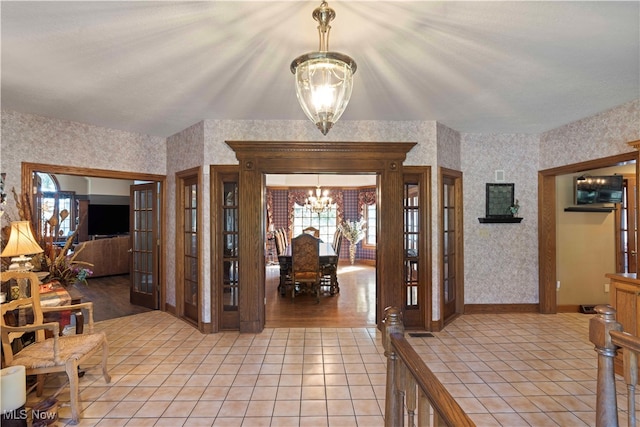 foyer with an inviting chandelier and light tile patterned floors