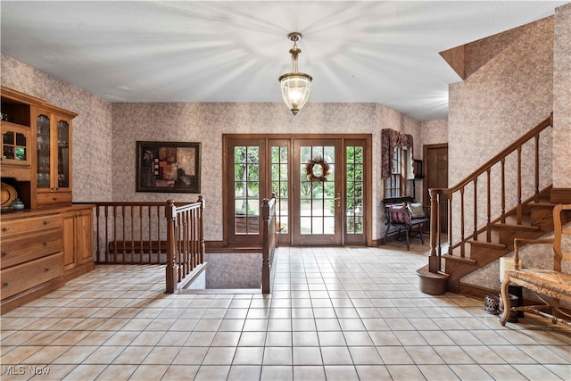 foyer entrance with an inviting chandelier and french doors