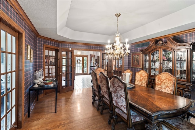 dining space featuring french doors, an inviting chandelier, and hardwood / wood-style floors