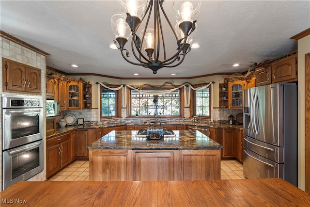 kitchen with a wealth of natural light, appliances with stainless steel finishes, and a kitchen island