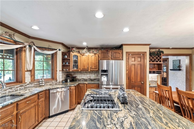 kitchen featuring sink, stone counters, decorative backsplash, stainless steel appliances, and light tile patterned floors