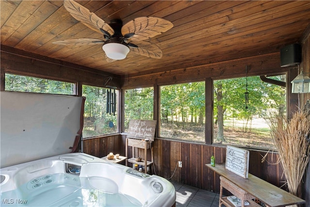 unfurnished sunroom featuring a wealth of natural light, ceiling fan, wooden ceiling, and a jacuzzi