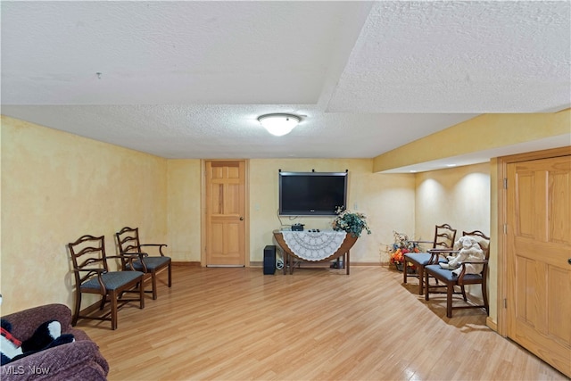 sitting room with wood-type flooring and a textured ceiling