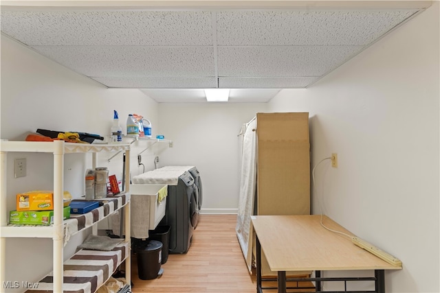 clothes washing area with light hardwood / wood-style flooring and independent washer and dryer