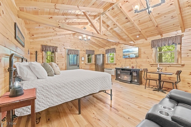 bedroom with wooden walls, wooden ceiling, multiple windows, and light hardwood / wood-style flooring