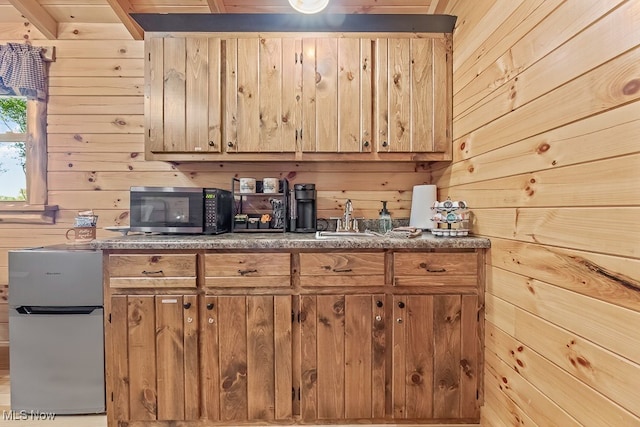 kitchen with wood walls, sink, and stainless steel appliances