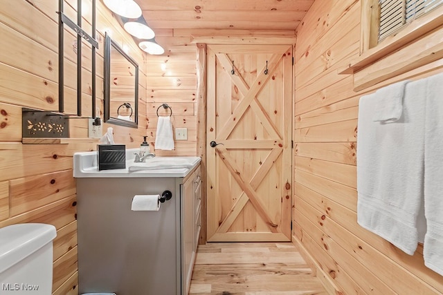 bathroom featuring hardwood / wood-style floors, wood ceiling, wood walls, and toilet