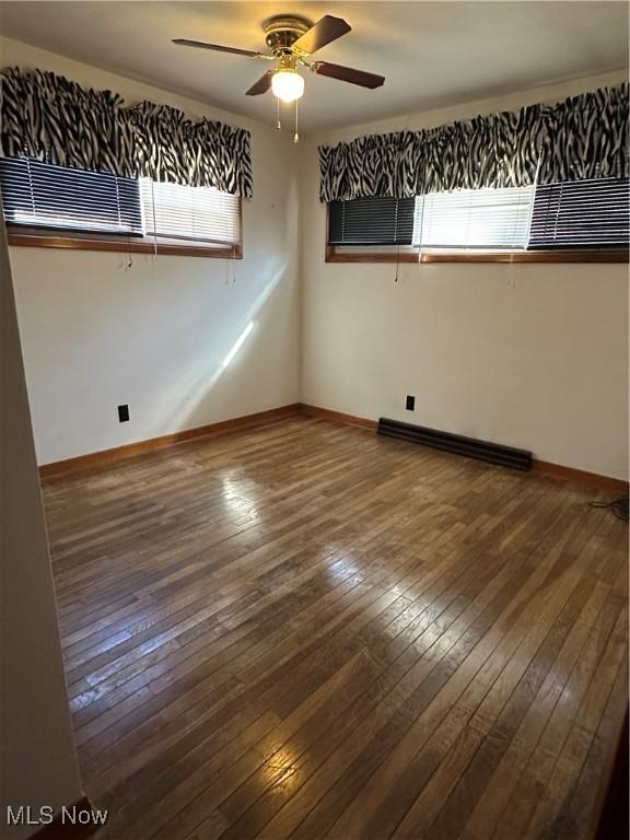 empty room with hardwood / wood-style flooring and ceiling fan