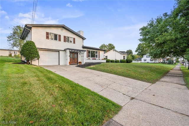 view of property featuring a front lawn and a garage