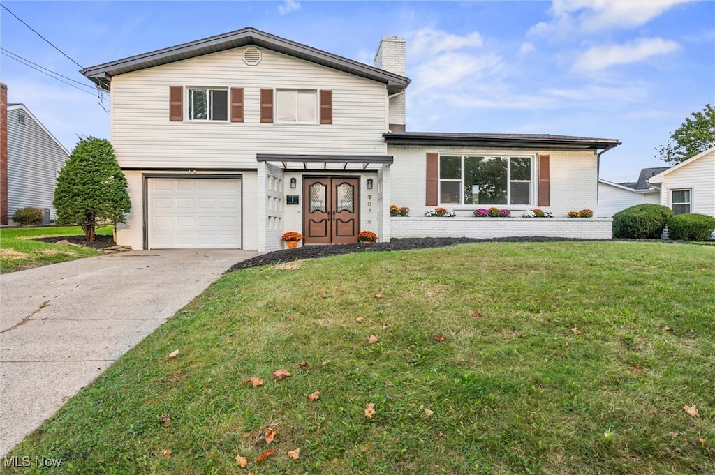 front of property featuring a front lawn and a garage