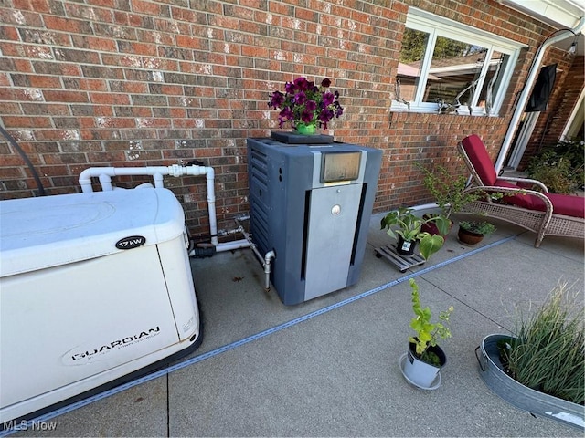 exterior details featuring a power unit, brick siding, and a wood stove