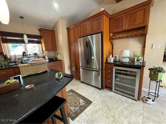 kitchen with brown cabinetry, freestanding refrigerator, decorative light fixtures, and wine cooler