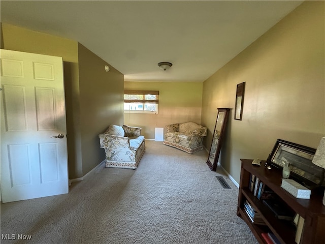 living area with carpet, visible vents, and baseboards