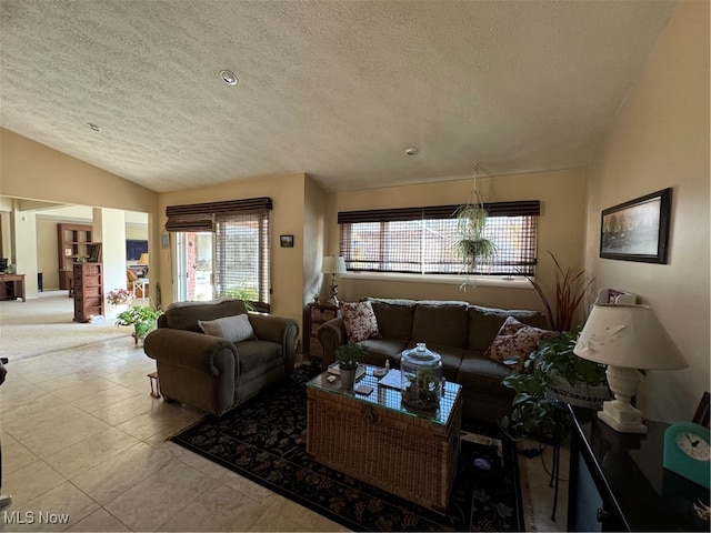 living area with lofted ceiling, a textured ceiling, and tile patterned floors