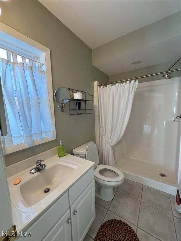 bathroom with curtained shower, vanity, toilet, and tile patterned floors